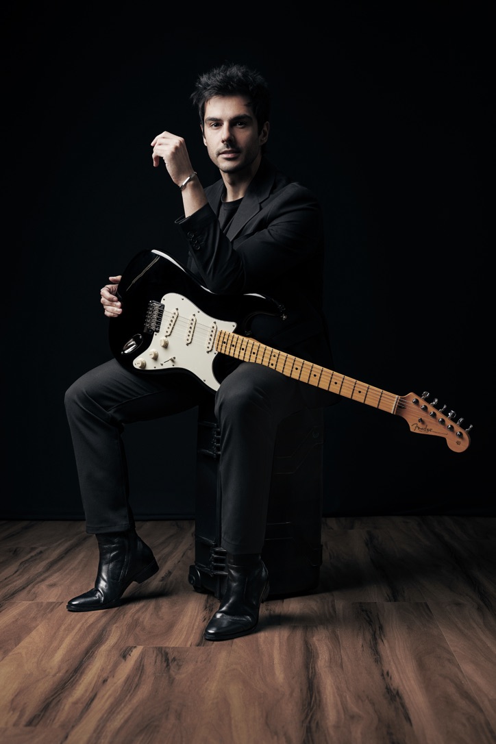 Marco Lafico com guitarra em pé sobre amplificador