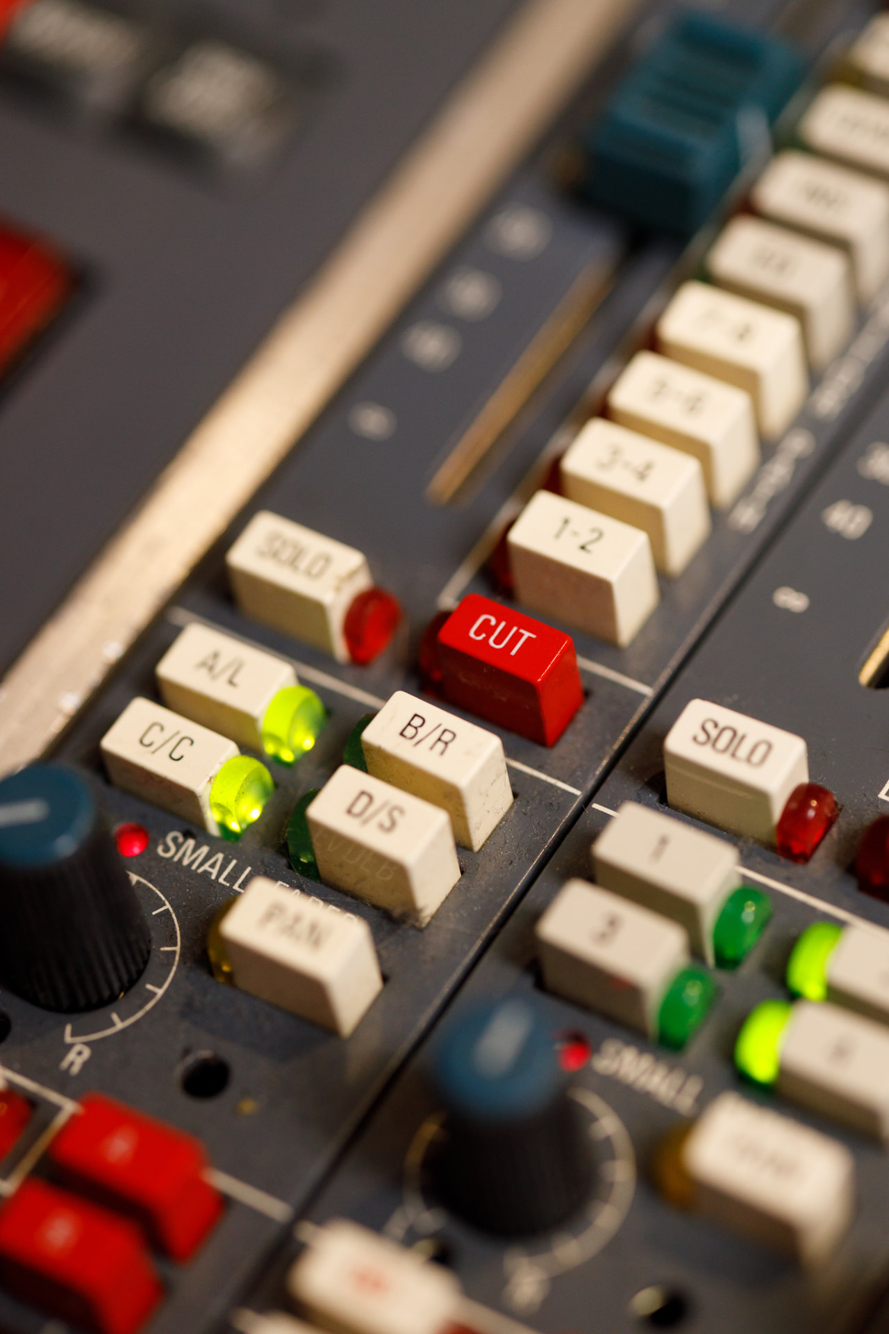 Detalhe dos botões CUT, SOLO e PAN do console Neve